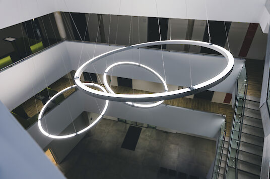 Grandes suspensions LED Ringo Star de Lightnet dans l'atrium moderne de la mairie de Delbrück